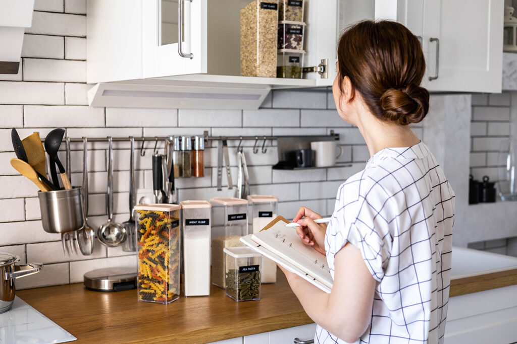 Private service professional taking inventory in a luxury pantry.